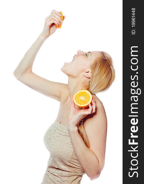 Woman drinking juice direct from an orange fruit
