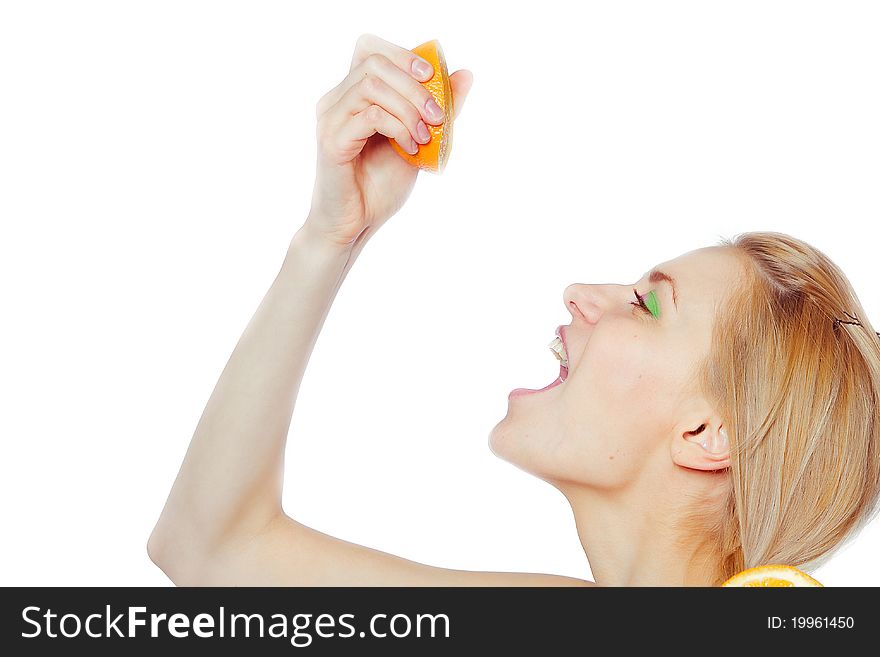 Woman drinking juice direct from an orange fruit
