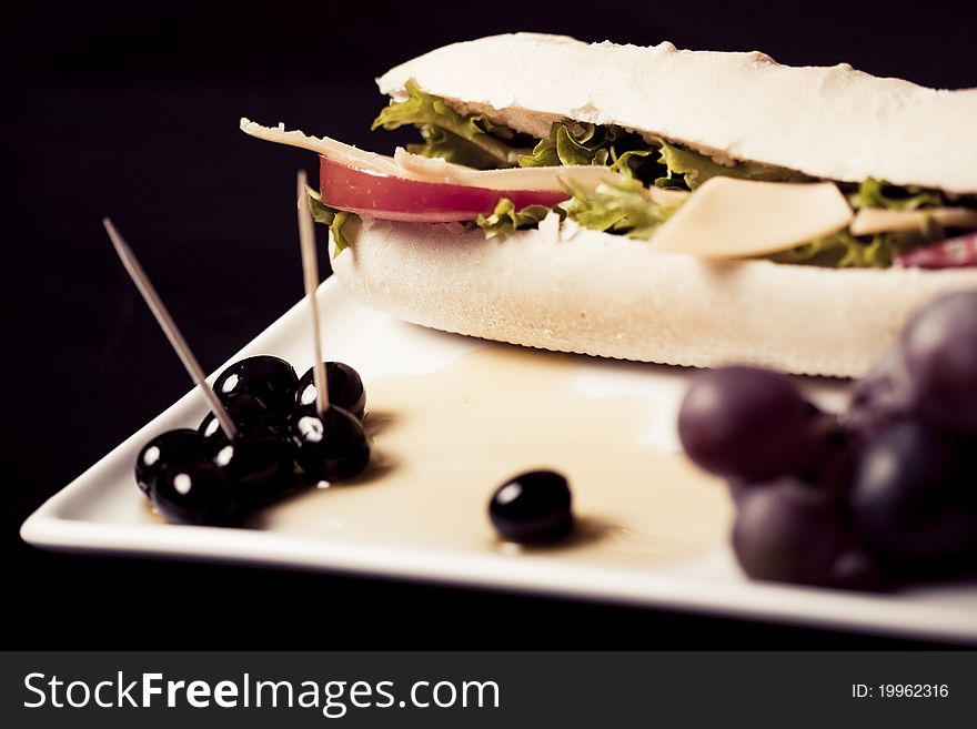 Long baguette sandwich with cheese,  fresh vegetables and olives. Long baguette sandwich with cheese,  fresh vegetables and olives