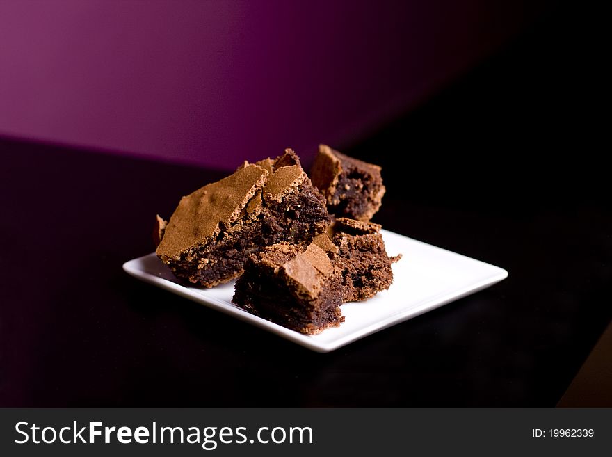 Chocolate Brownies on a White Platter on a restaurant table. Chocolate Brownies on a White Platter on a restaurant table