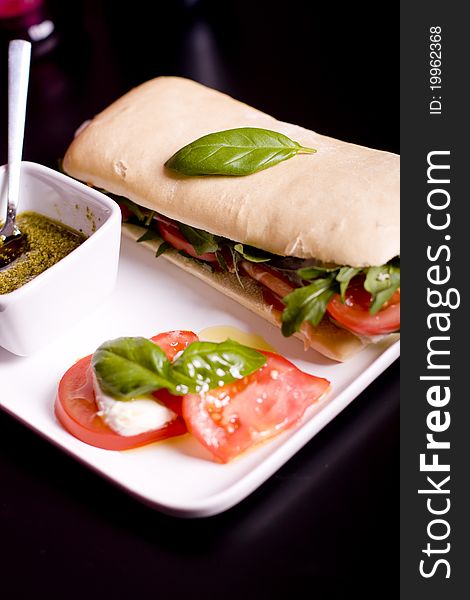 Long baguette sandwich with ham, fresh vegetables and pesto. Long baguette sandwich with ham, fresh vegetables and pesto