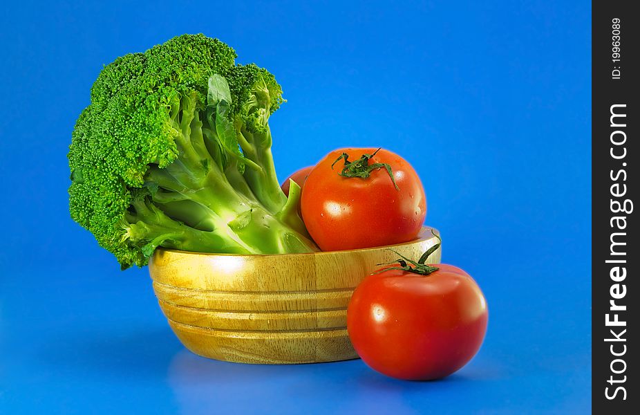 Broccoli with tomatoes on blue