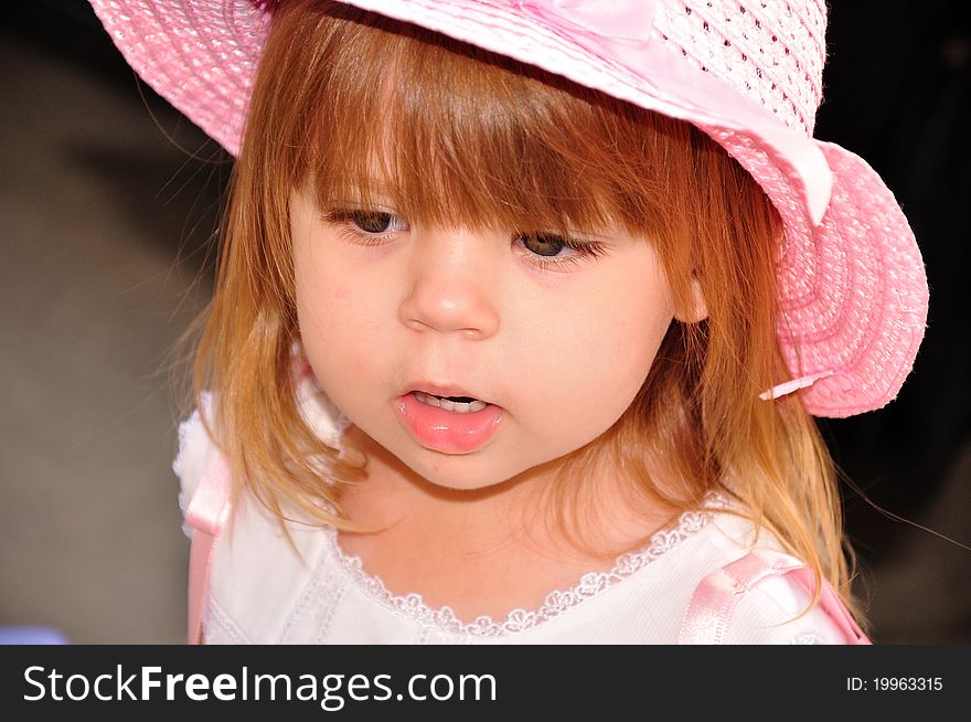 Toddler wearing a pink hat while thinking of her next step. Toddler wearing a pink hat while thinking of her next step.