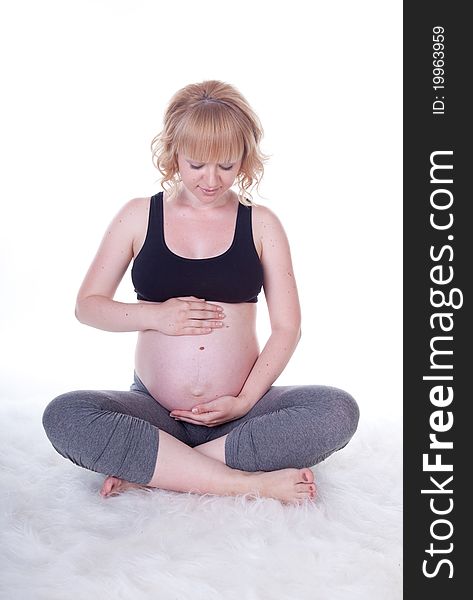 Beautiful pregnant woman doing physical exercises, studio shot