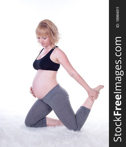 Beautiful pregnant woman doing physical exercises, studio shot