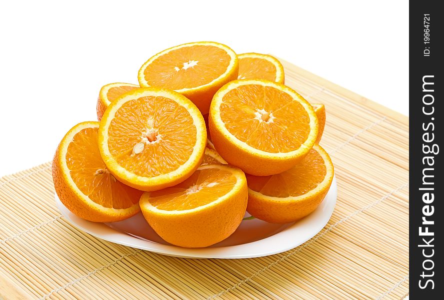 Ripe oranges cut in half lying on a plate