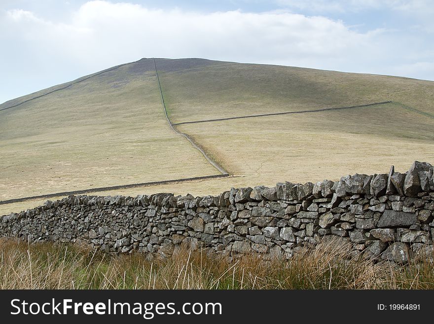 Dry stone walls make a pattern over a hillside leading to the peak. Dry stone walls make a pattern over a hillside leading to the peak.