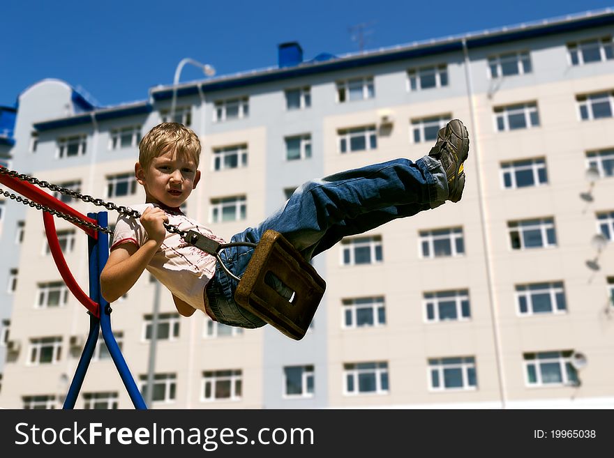 Young boy shakes on a swing. Young boy shakes on a swing