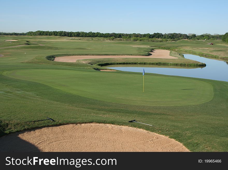 View of a green with approach shot over water hazard and sand trap. View of a green with approach shot over water hazard and sand trap