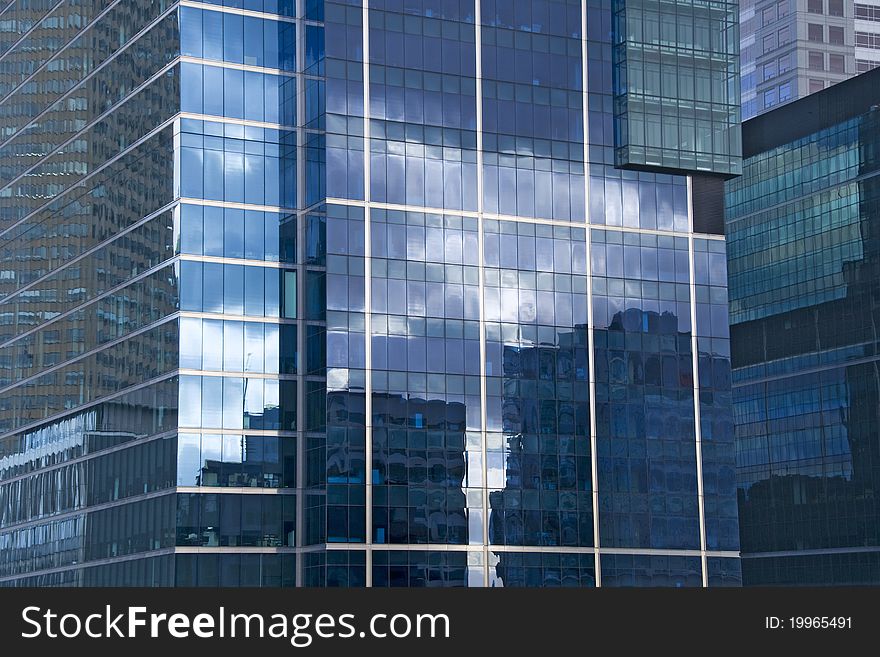 An office building in Melbourne, Australia reflects a cloudy sky and neighboring structures. An office building in Melbourne, Australia reflects a cloudy sky and neighboring structures