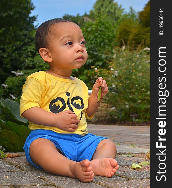 9 month old baby boy looking in wonder at a reflecting pool/koi pond. 9 month old baby boy looking in wonder at a reflecting pool/koi pond