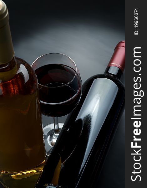 Bottle and glass of wine on a dark background