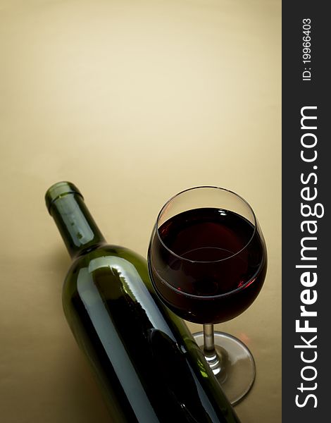 Bottle and glass of wine on a dark background