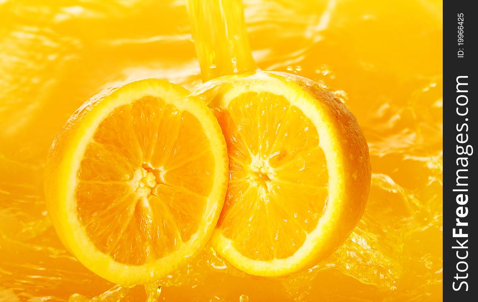 Fresh oranges falling in juice with lot of huge splashes