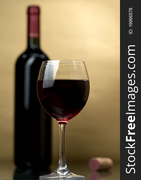 Bottle and glass of wine on a dark background. Bottle and glass of wine on a dark background