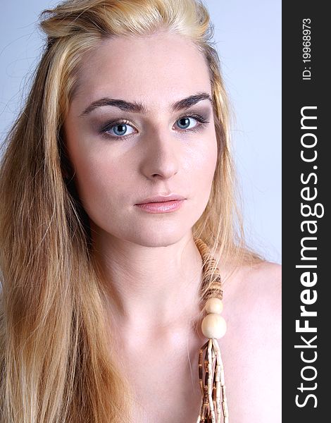 Portrait of pretty blond girl wearing wooden beads, closeup.
