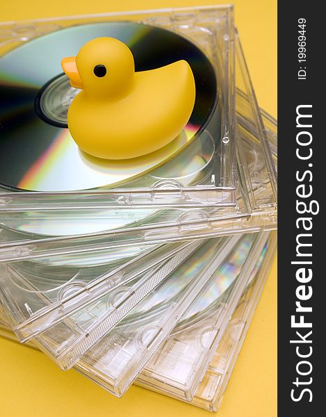 A yellow rubber duck on bunch of cd. A yellow rubber duck on bunch of cd