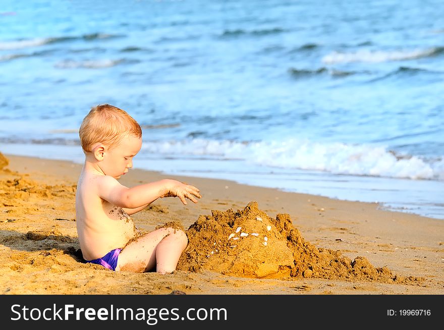 Baby boy playing on beach in sunset. Baby boy playing on beach in sunset