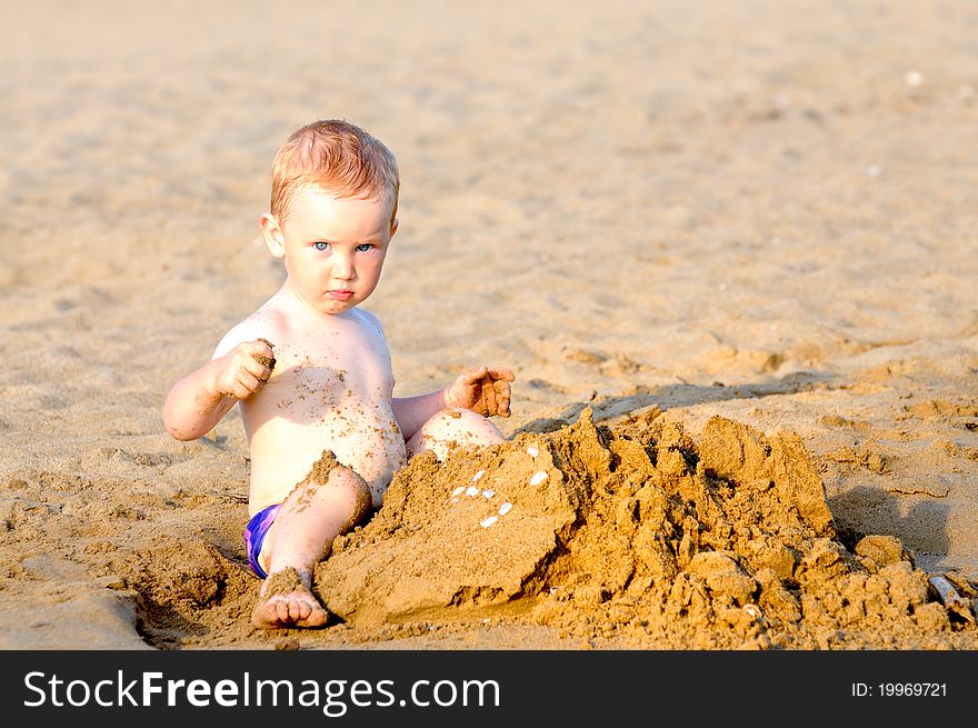 Baby boy playing on beach in sunset. Baby boy playing on beach in sunset