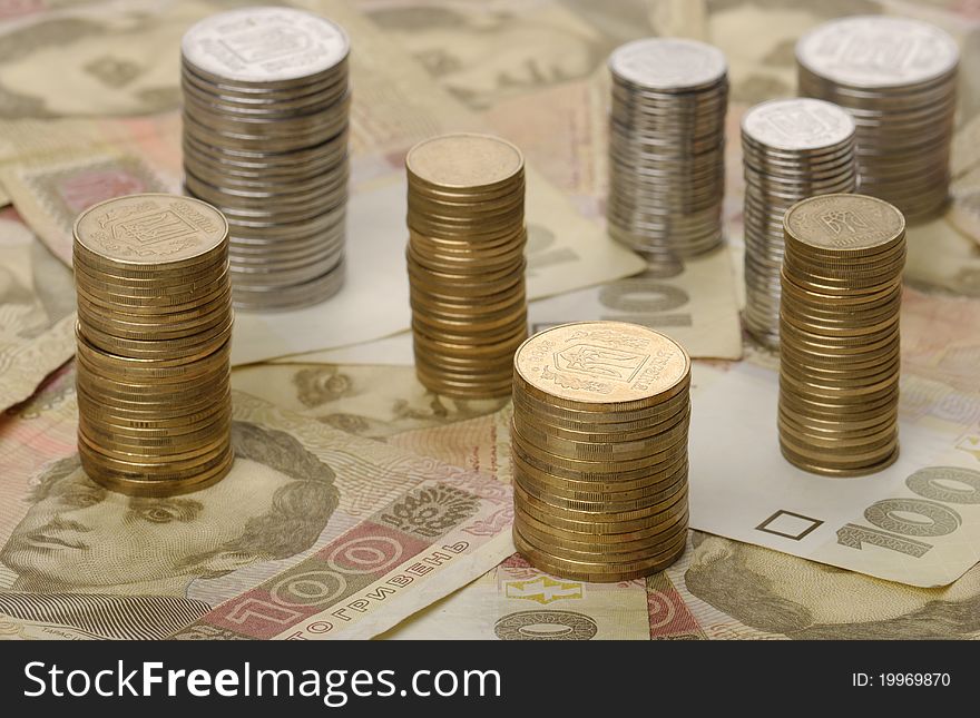 Stacks of coins on background of banknotes, ukrainian money