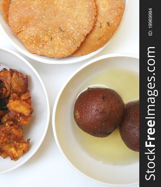 Variety of indian snacks on white background.