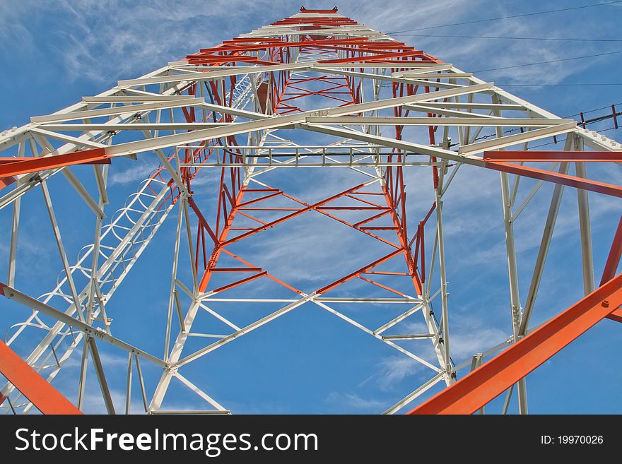 A communication tower against the sky - red, white high in the morning. A communication tower against the sky - red, white high in the morning.