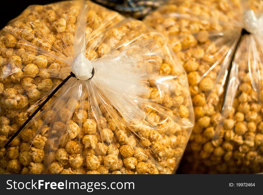 A bulk of caramel flavored popcorn in a tied plastic bag