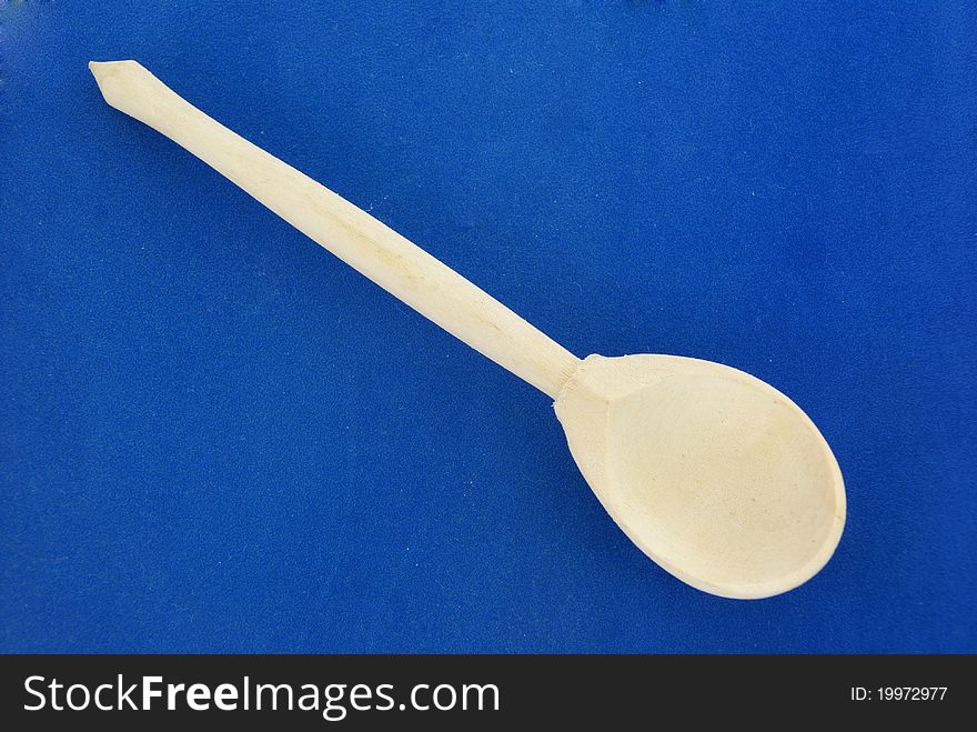 A traditional wooden spoon on blue background