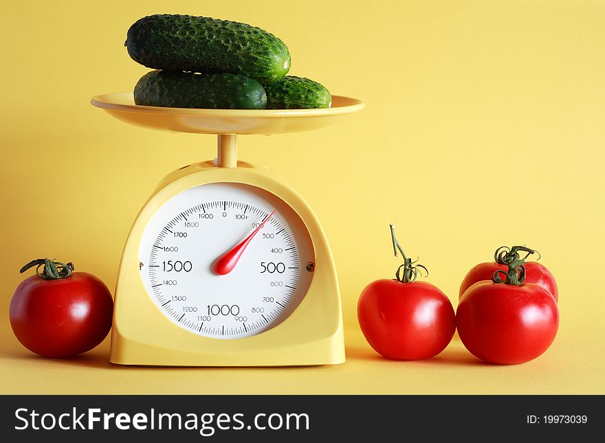 Still life with modern kitchen scale and vegetables on yellow background. Still life with modern kitchen scale and vegetables on yellow background