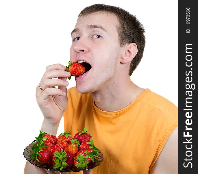 Young the man eats a strawberry isolated