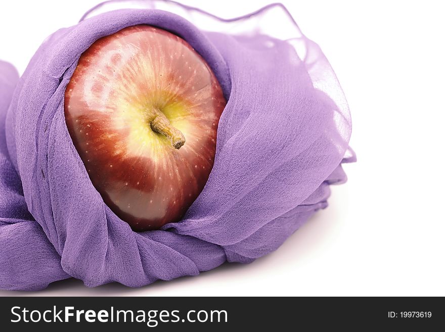 An apple wrapped with a beautiful deep violet silk scarf. Showing how nice an apple in a silk scarf. An apple wrapped with a beautiful deep violet silk scarf. Showing how nice an apple in a silk scarf.