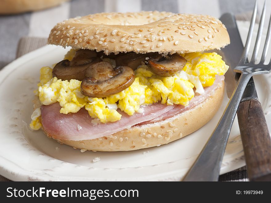 Bagel filled with scrambled egg, mushrooms and bacon. Bagel filled with scrambled egg, mushrooms and bacon