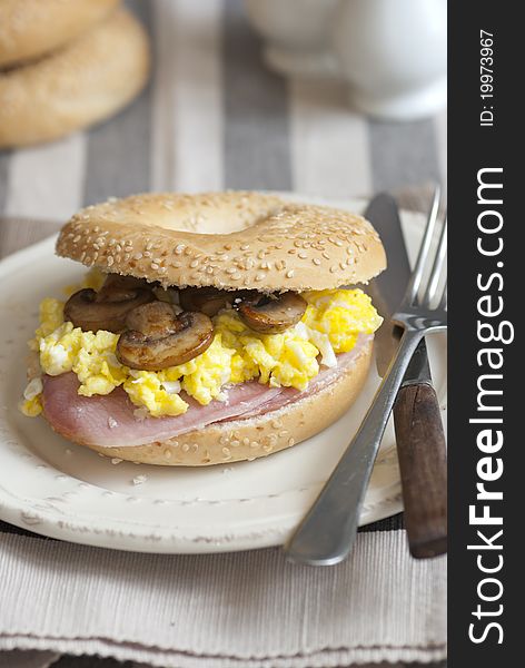 Bagel filled with scrambled egg, mushrooms and bacon. Bagel filled with scrambled egg, mushrooms and bacon