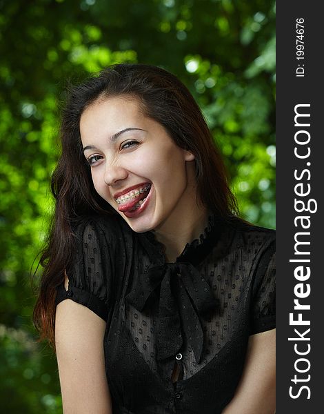 Model girl with braces on a background of trees. Model girl with braces on a background of trees