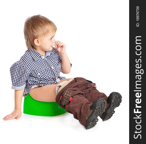 A boy sitting on the pot. Isolated on a white background