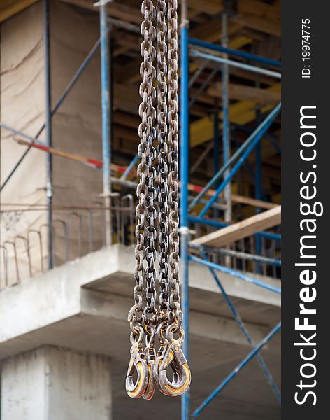 Four crane hooks from below against the background of the construction. Four crane hooks from below against the background of the construction