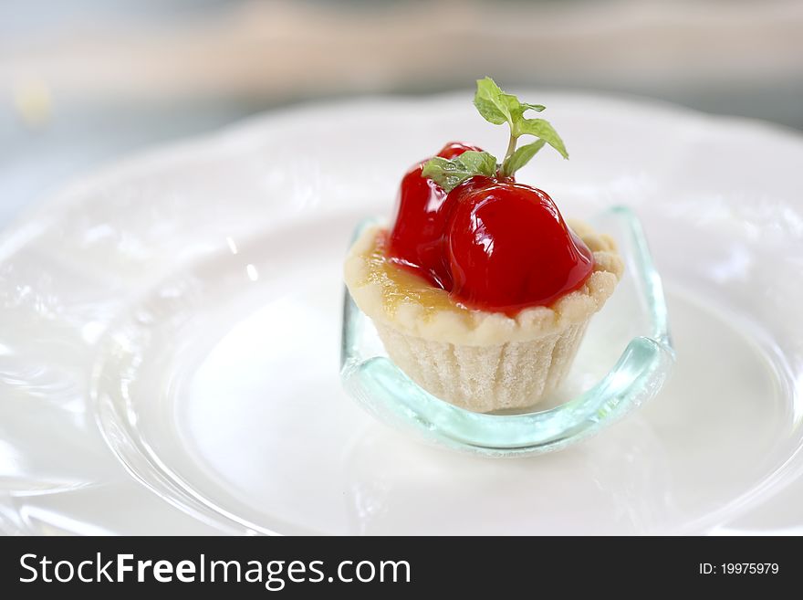 Mini cherry fruit tarts on dish Close-up in shallow DOF