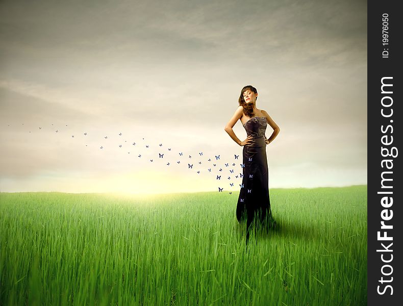 Beautiful elegant woman on a green meadow with butterflies flying from her dress. Beautiful elegant woman on a green meadow with butterflies flying from her dress