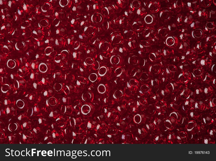 Red polished glass beads background, macro