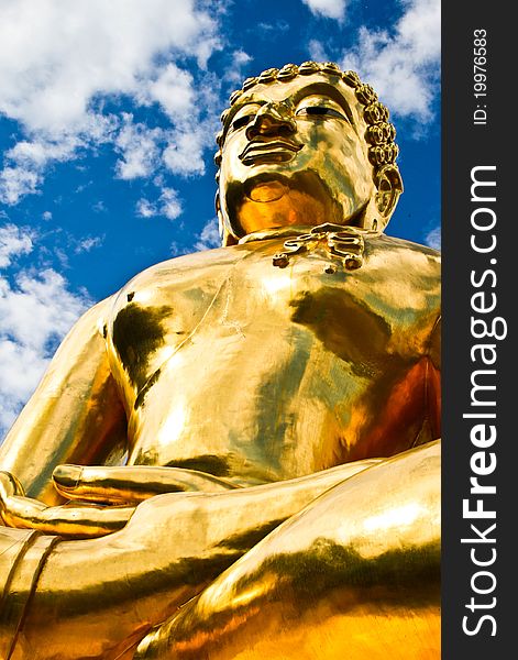 Golden buddha with blue sky and white crown