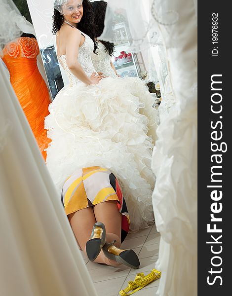 Woman making adjustment to wedding gown in professional fashion designer studio. Woman making adjustment to wedding gown in professional fashion designer studio
