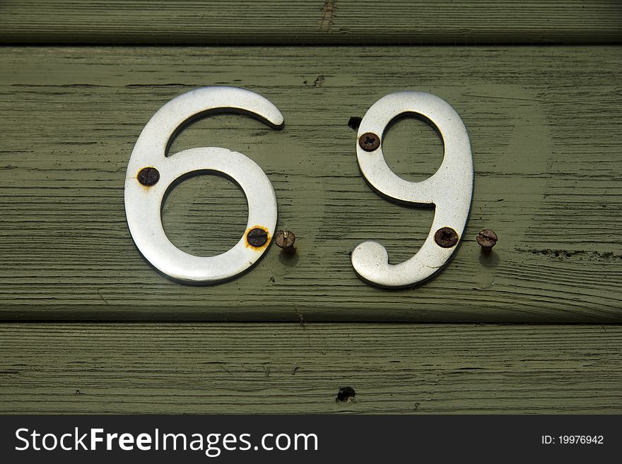 Metal number 69 on green painted front door. Metal number 69 on green painted front door