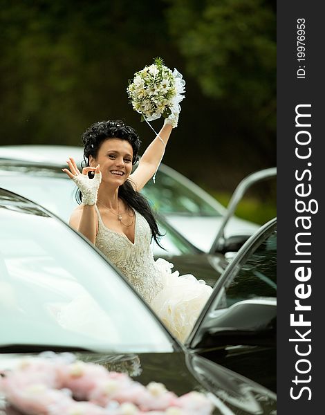 Portrait of the bride near the car showing 'ok' gesture. Portrait of the bride near the car showing 'ok' gesture