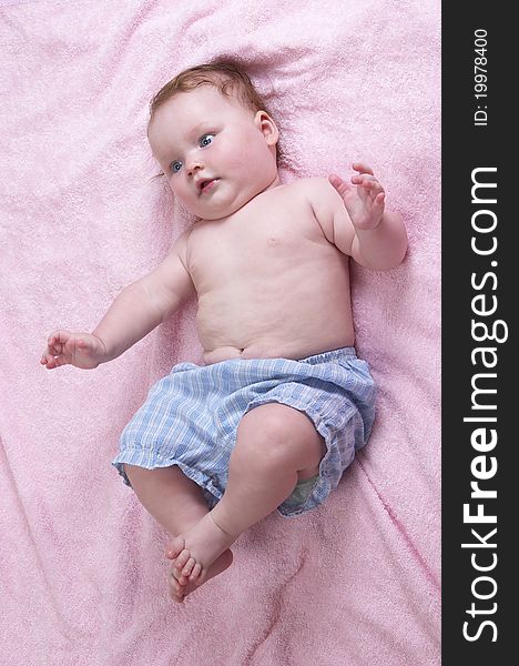 Little baby girl over soft pink towel background. Little baby girl over soft pink towel background