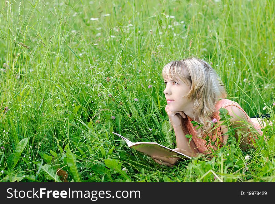 Young woman with a book on the grass