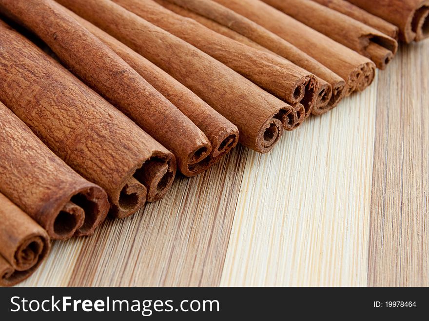 A group of whole cinnamon sticks on a wooden board