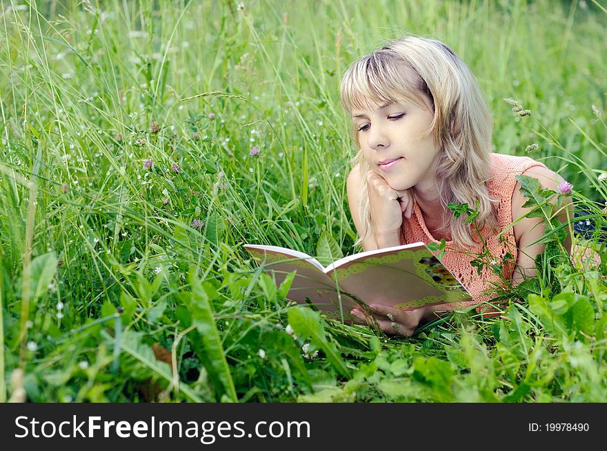Young woman with a book on the grass
