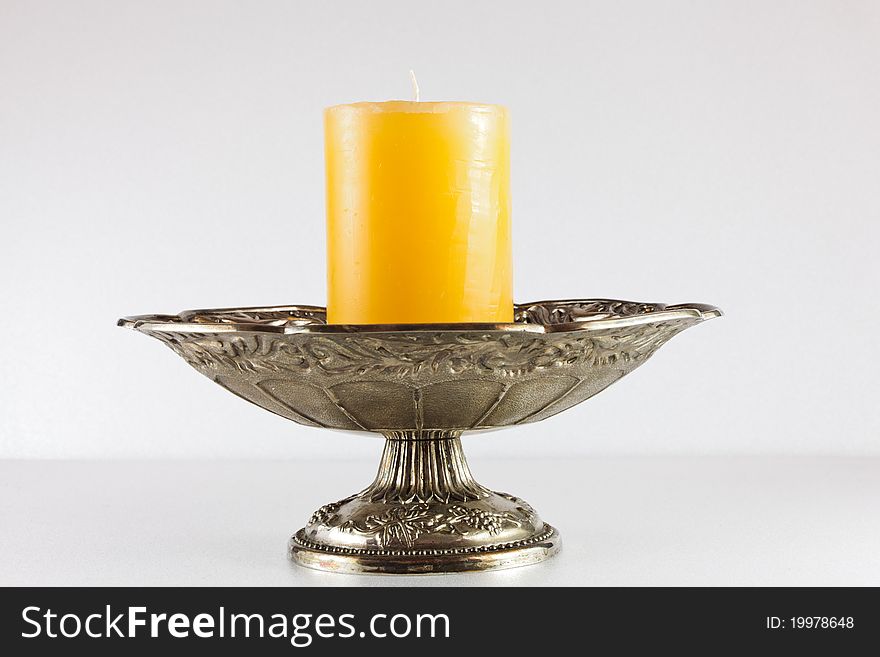 Yellow candle in silver bowl. Yellow candle in silver bowl