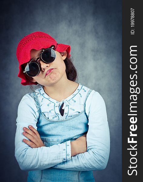 Little girl in red hat looking disappointed and fold her arms. Little girl in red hat looking disappointed and fold her arms