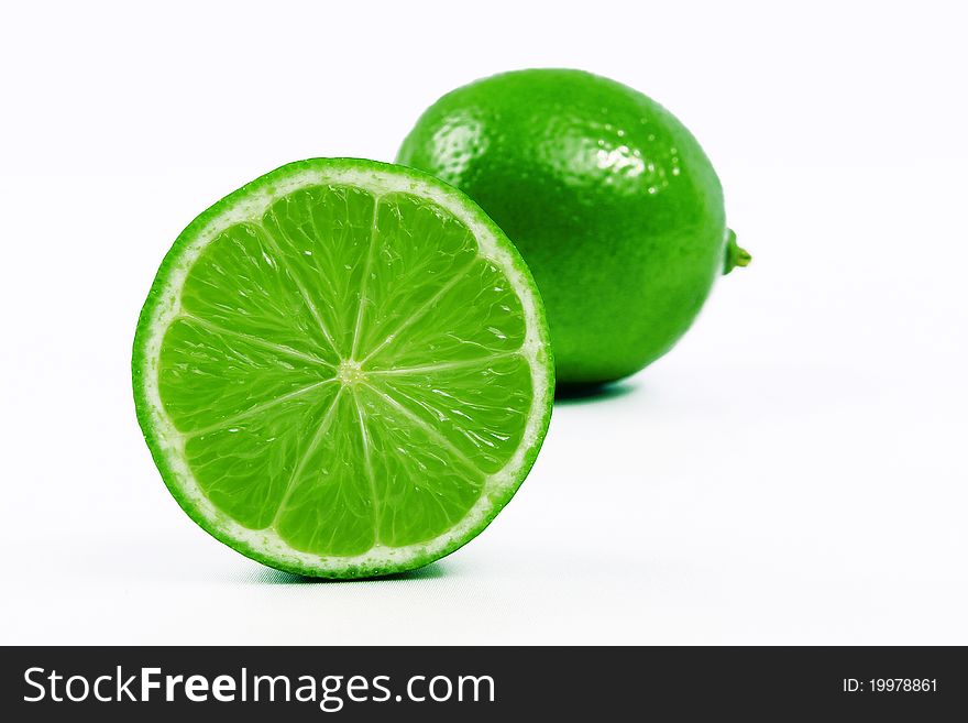 1 / 2 lime in the foreground with a lime behind. 1 / 2 lime in the foreground with a lime behind